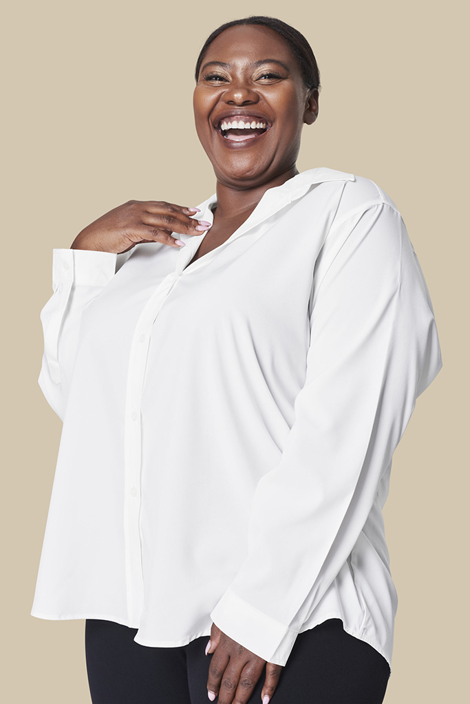 Portrait of a smiling black plus-size woman wearing a white shirt